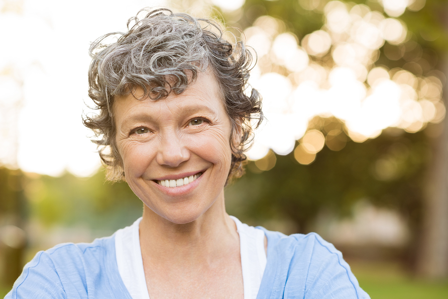 Portrait of senior woman relaxing at park. Close up face of happ