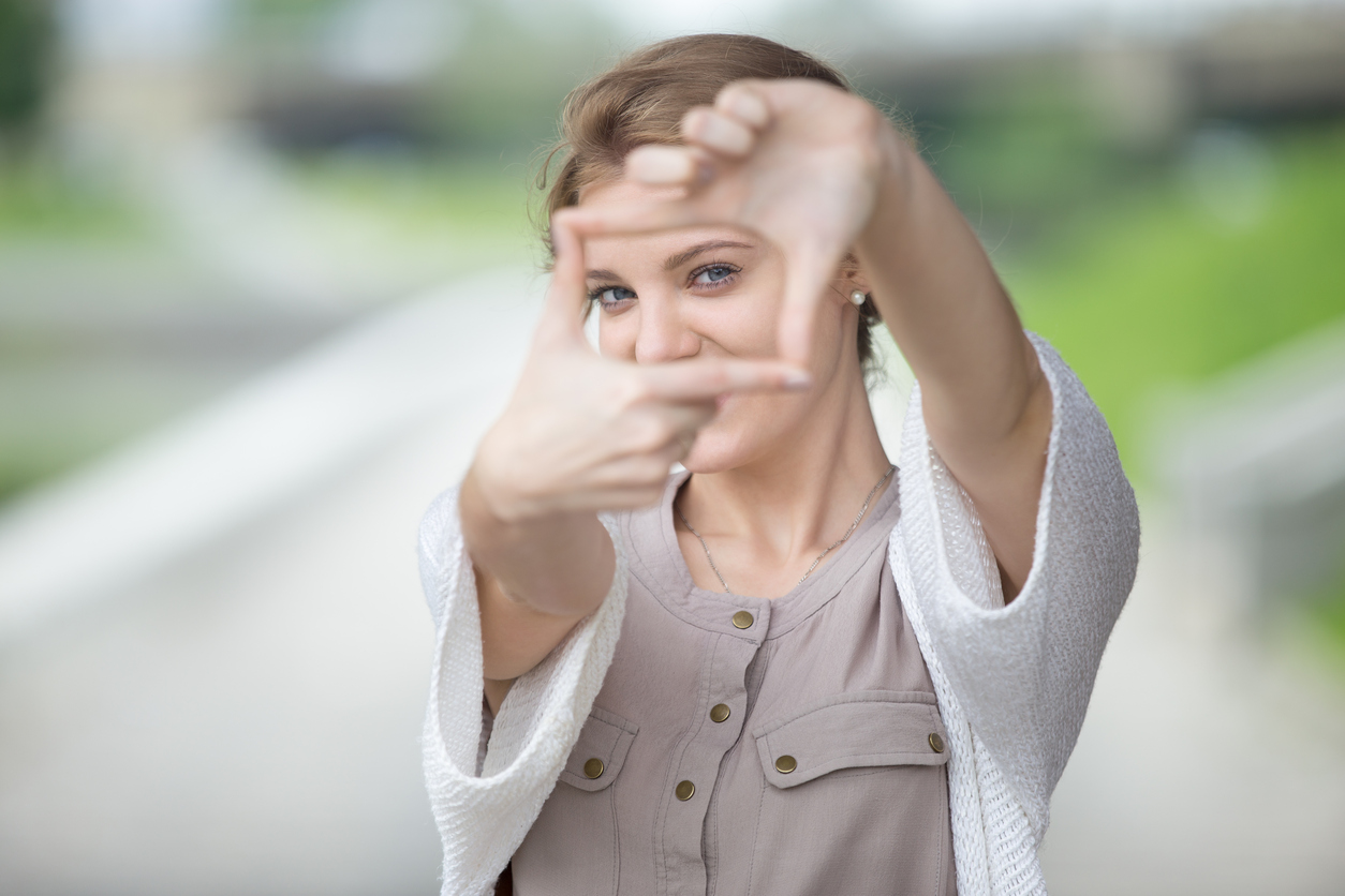 Portrait of playful woman using hands to make a frame