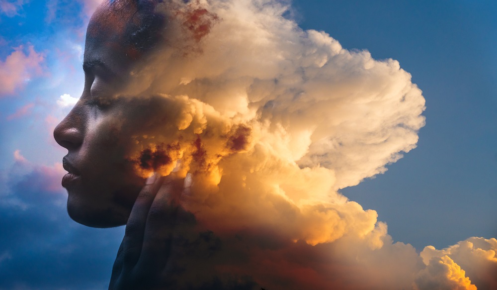 Double exposure, portrait of a dark-skinned woman and a striking sunset