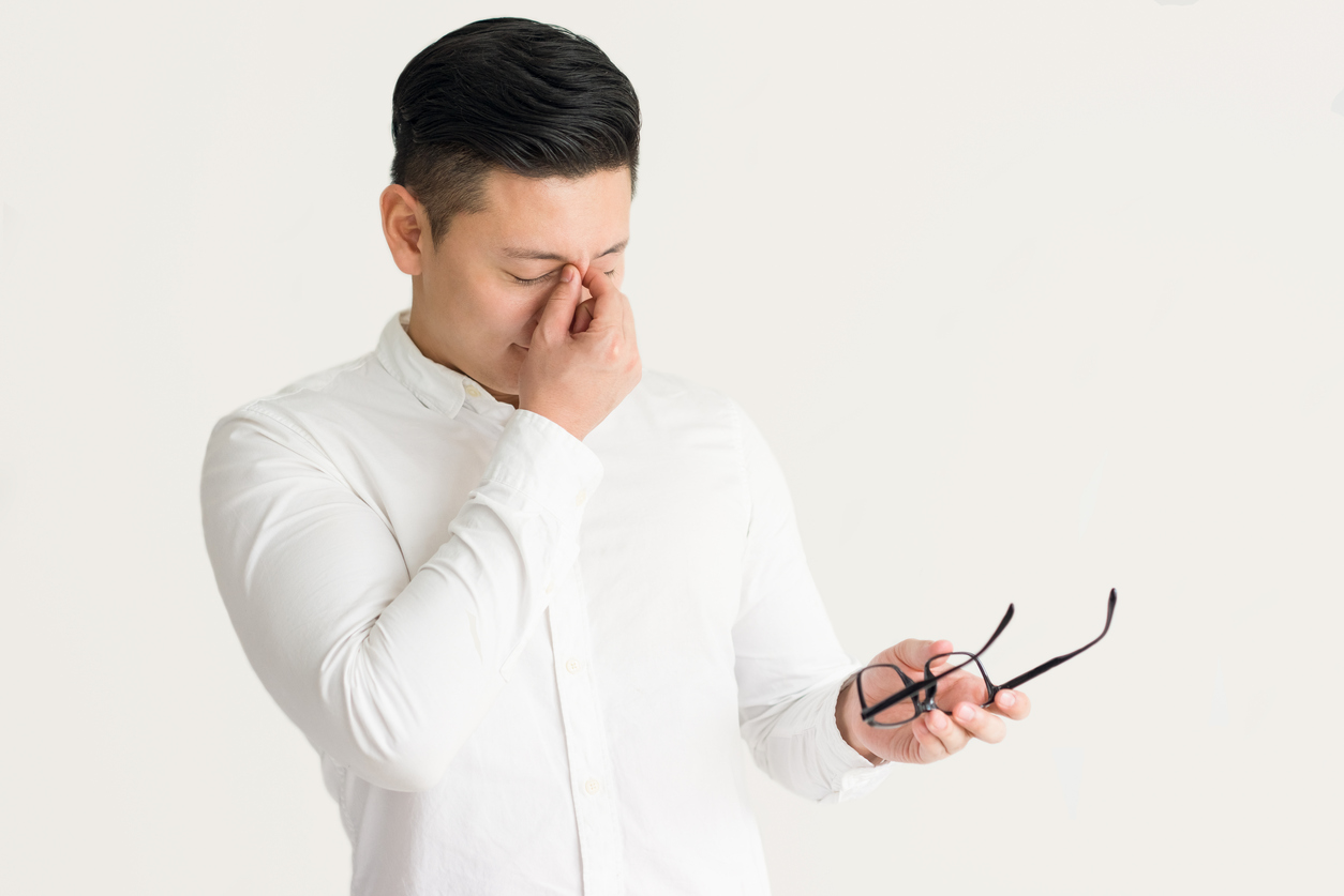 Exhausted businessman having pain in eyes