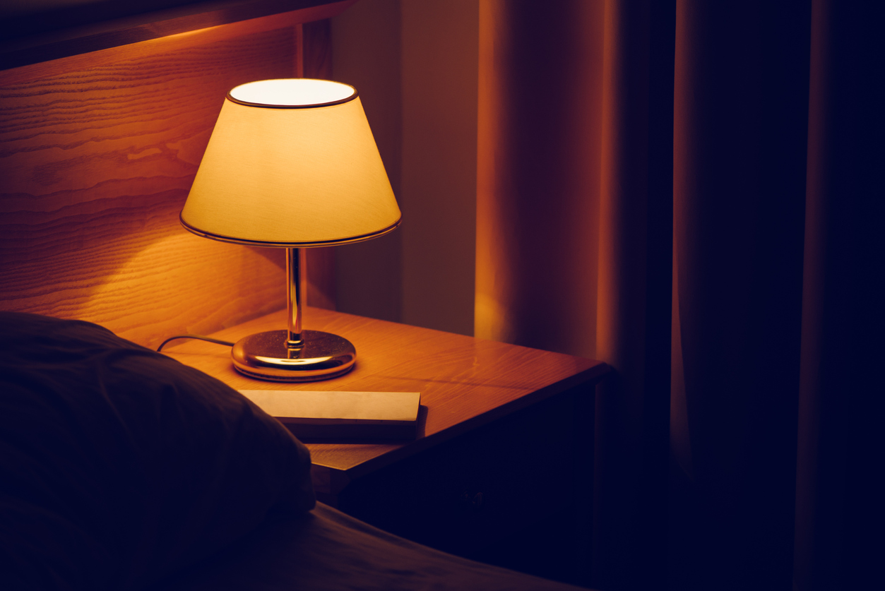Dim lamp on table in bedroom for eye strain