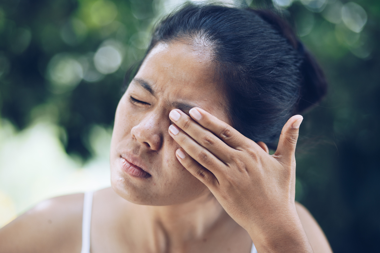Woman experiencing eye sensitivity to light in one eye