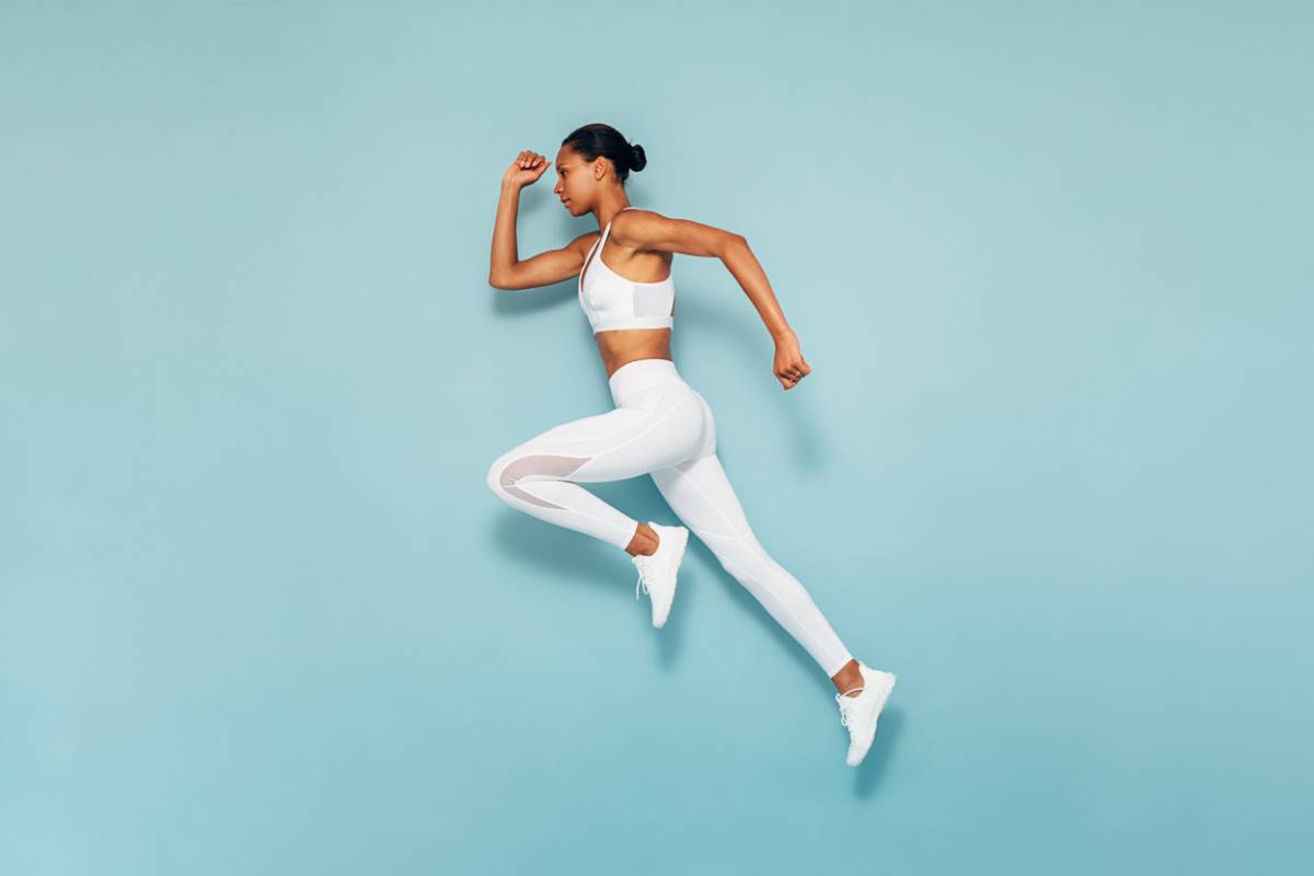 Female runner against a blue background (example of athelets who have had Lasik)