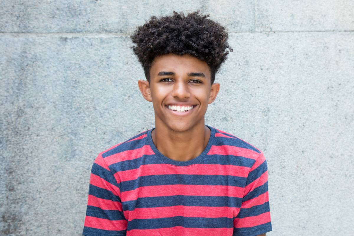 Teen smiling wondering if he can get lasik.