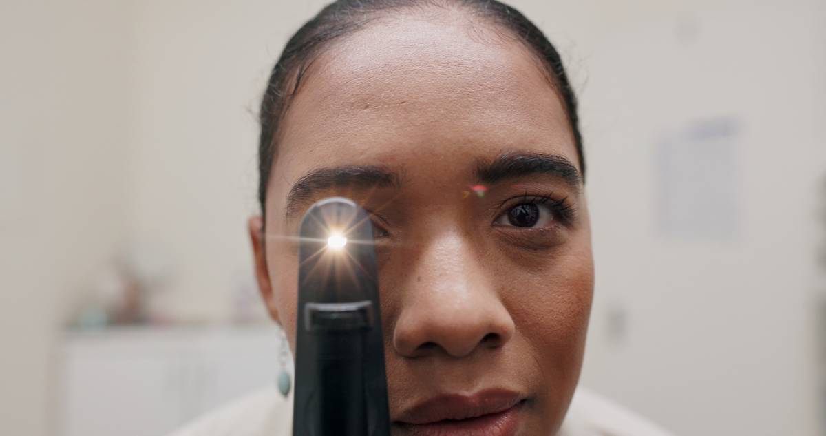 Optometrist conducting checkup using retinoscope test.